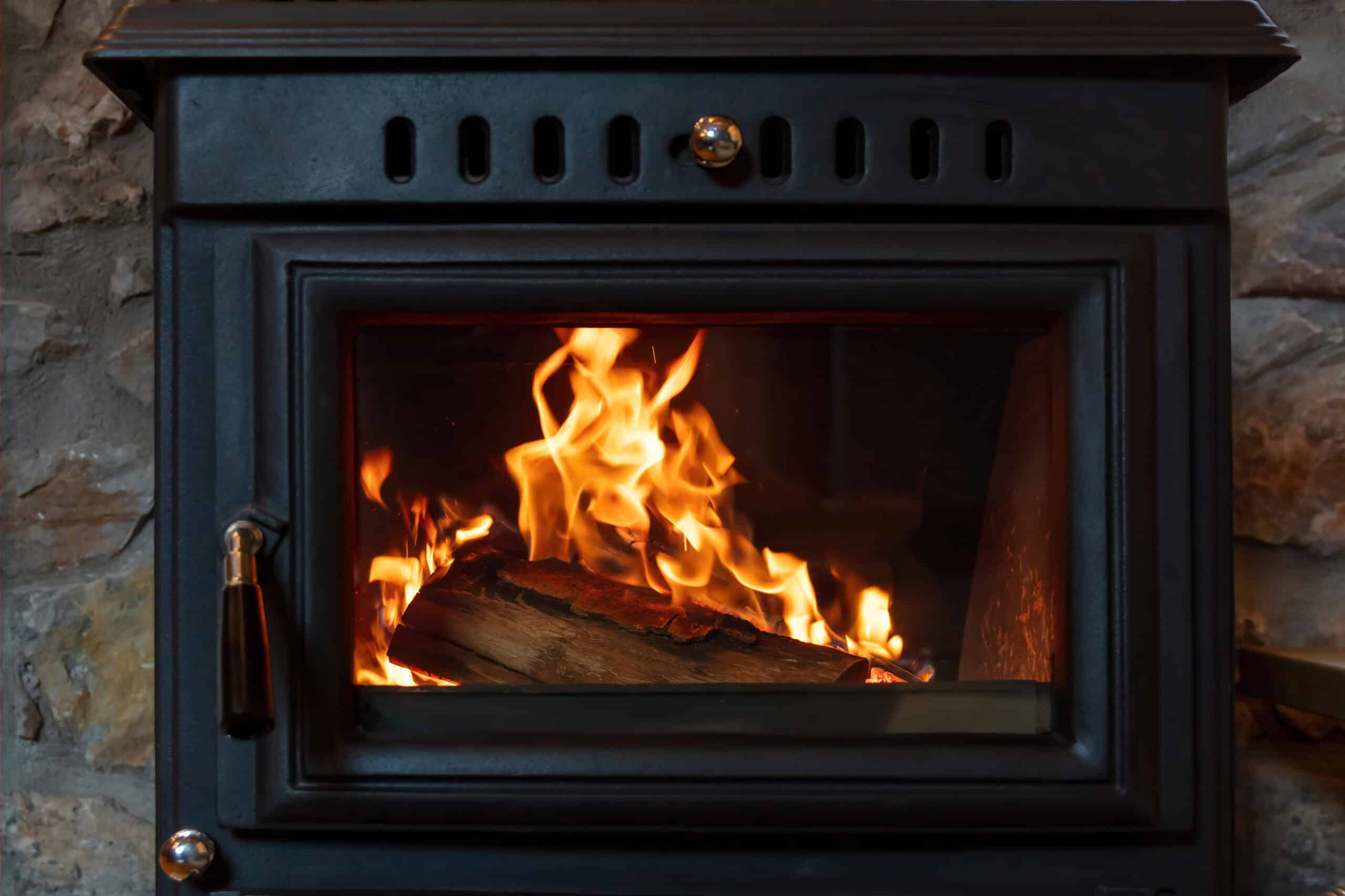 burning fire in a wood stove fireplace radiates heat, warm home interior,