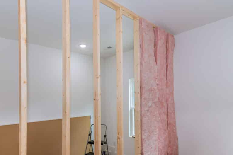installing interior thermal and sound insulation rockwool mineral fiber glass wool among beams framing for wall