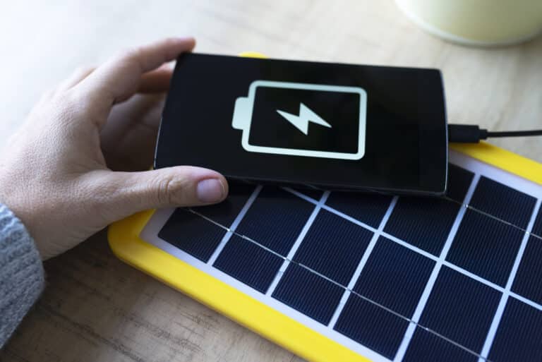 renewable energy technology, solar panel charging a mobile phone battery