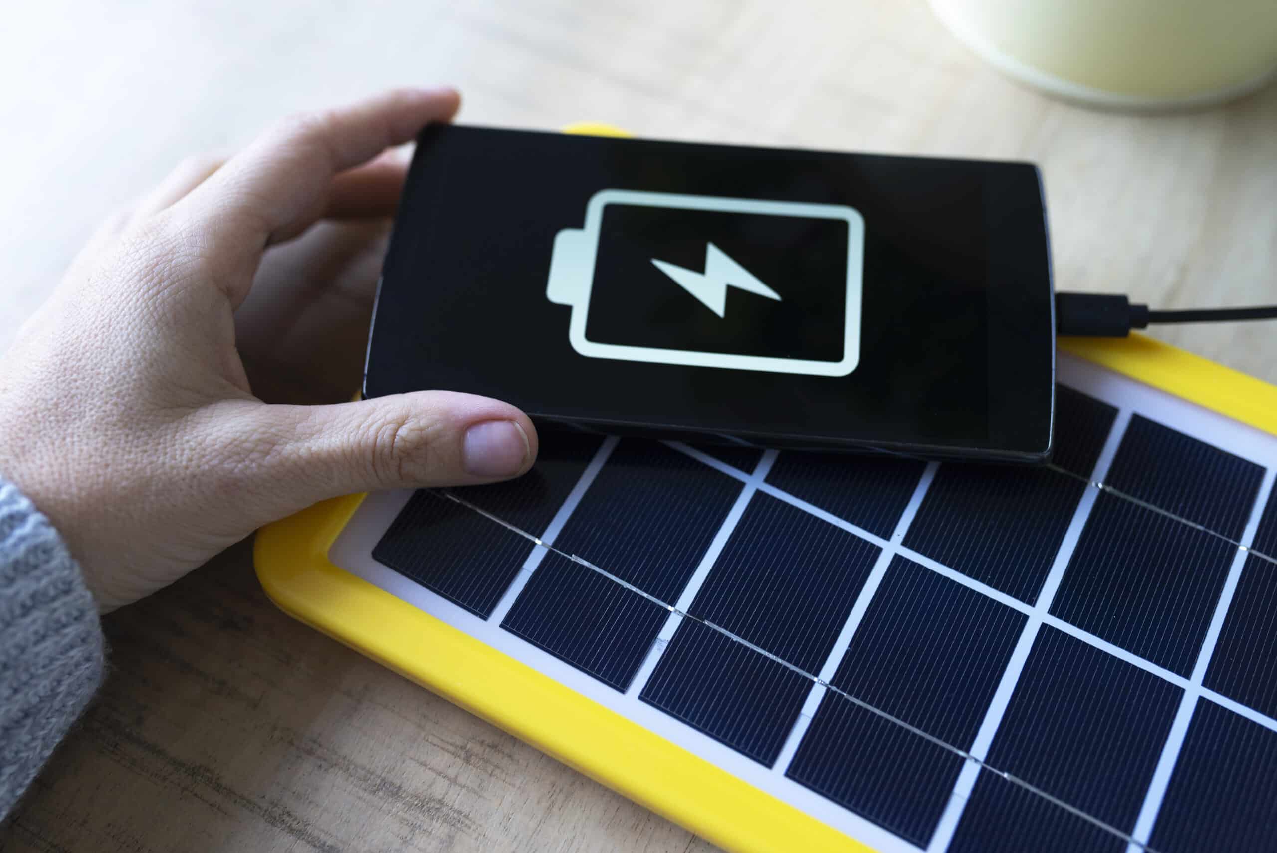 renewable energy technology, solar panel charging a mobile phone battery