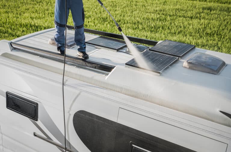 rv industry worker cleaning camper van roof and motorhome solar