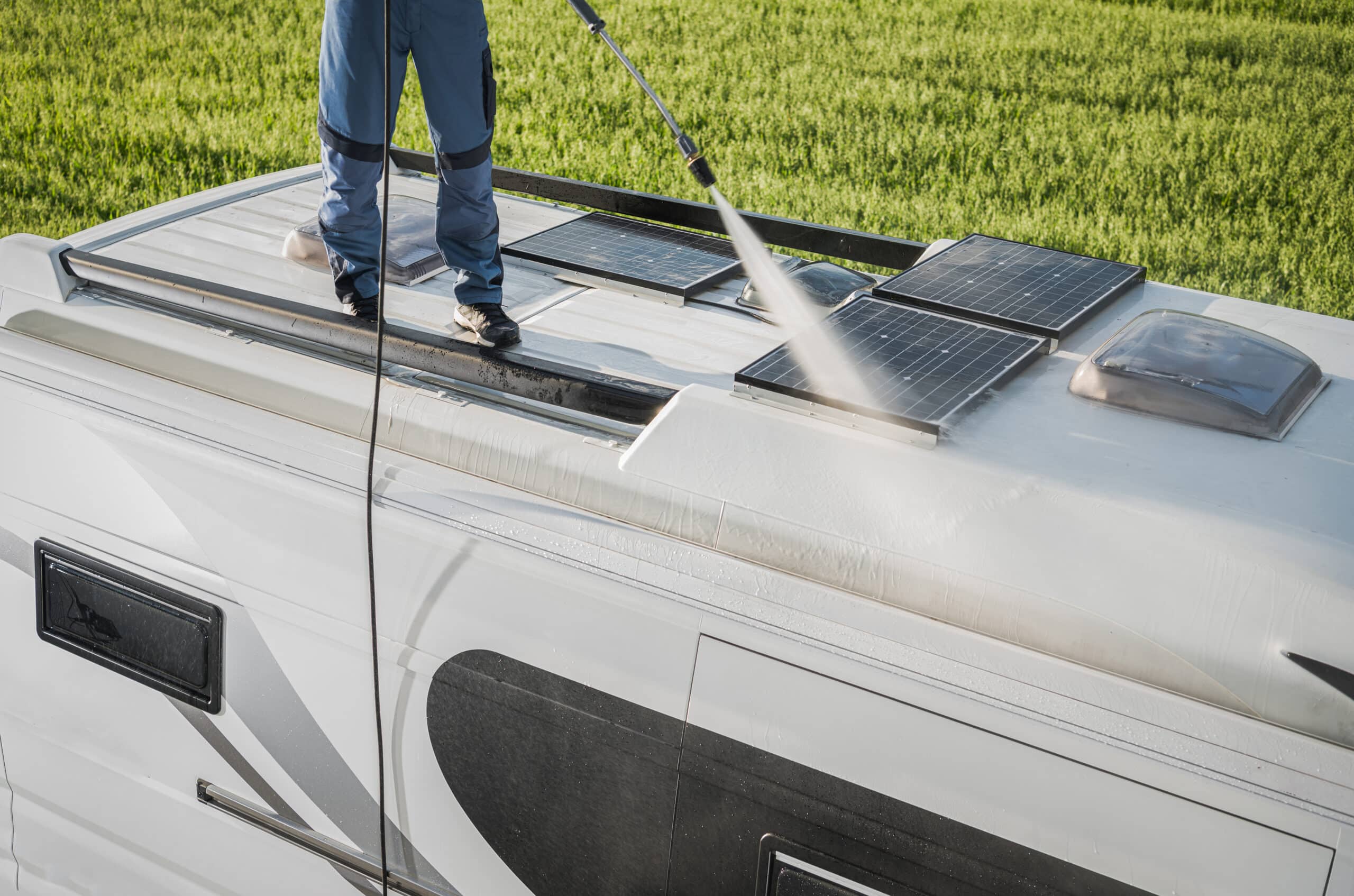rv industry worker cleaning camper van roof and motorhome solar