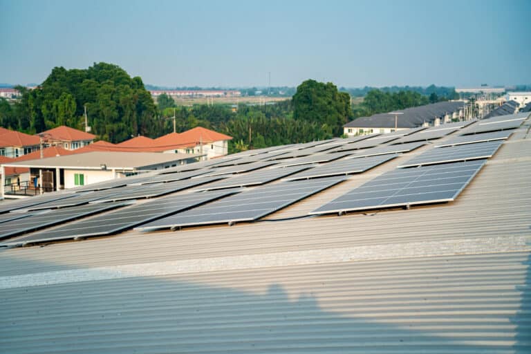solar panel installer installing solar panels on roof of warehouse