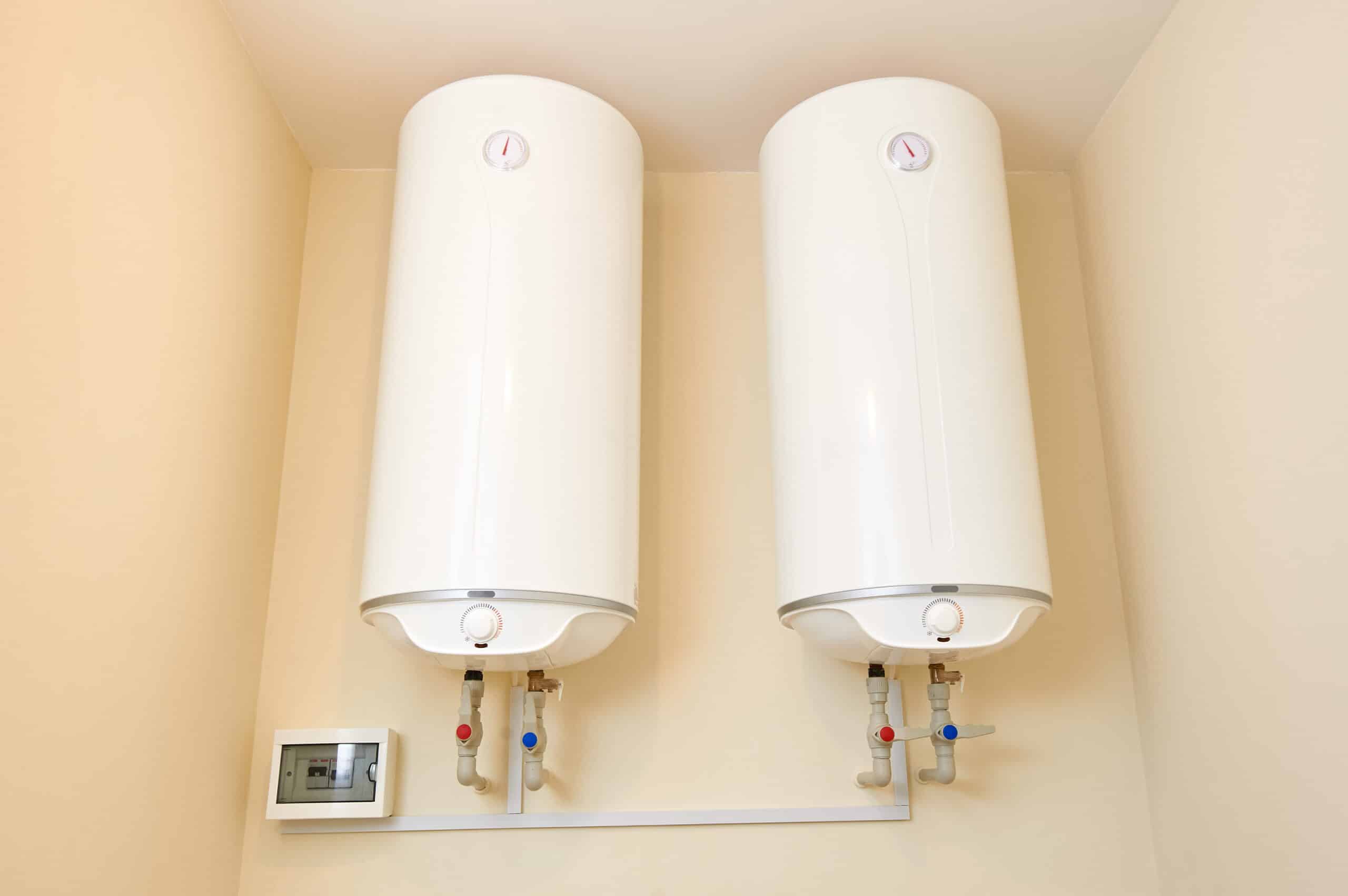 two electric water heaters on the wall. home wall mounted two water heating boilers.