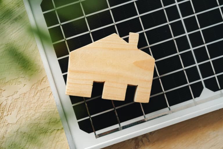 wooden house miniature and solar panel close up