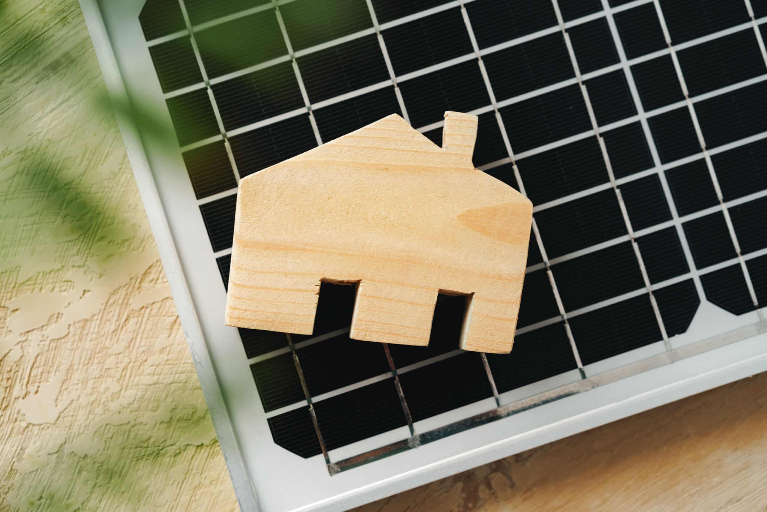 wooden house miniature and solar panel close up