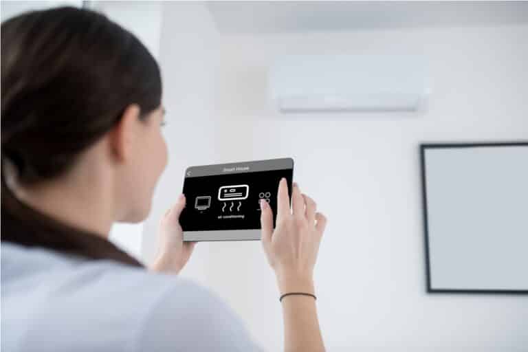 woman turning on an air conditioning unit 2021 12 09 17 22 21 utc