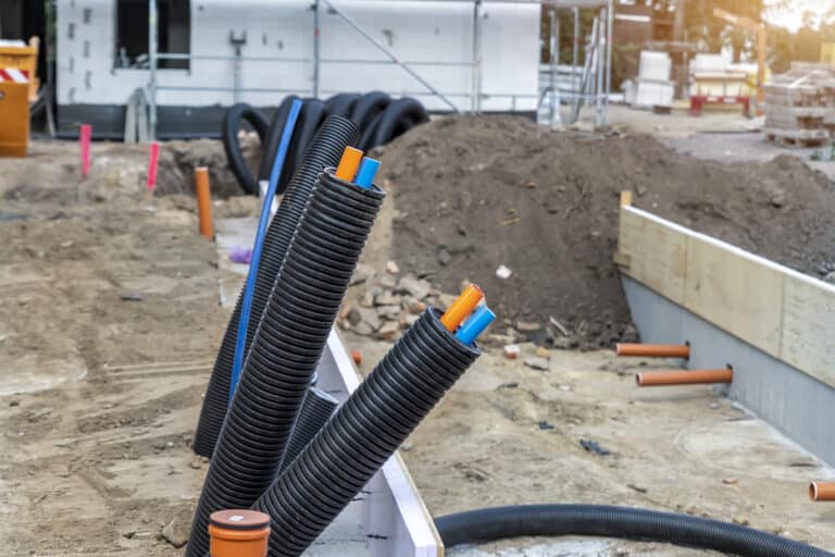 black pvc flexible corrugated plastic insulation pipes tubing of electrical cables wire at undeground installation. new modern building construction site with engineering pipeline drainage technology