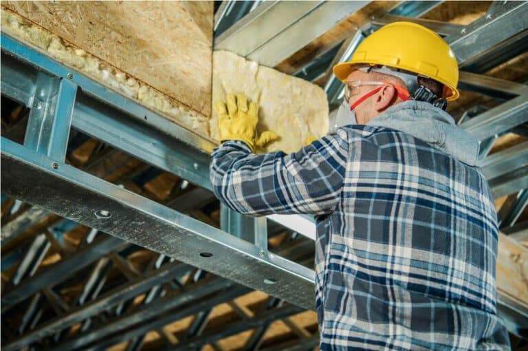 construction worker insulating building ceiling
