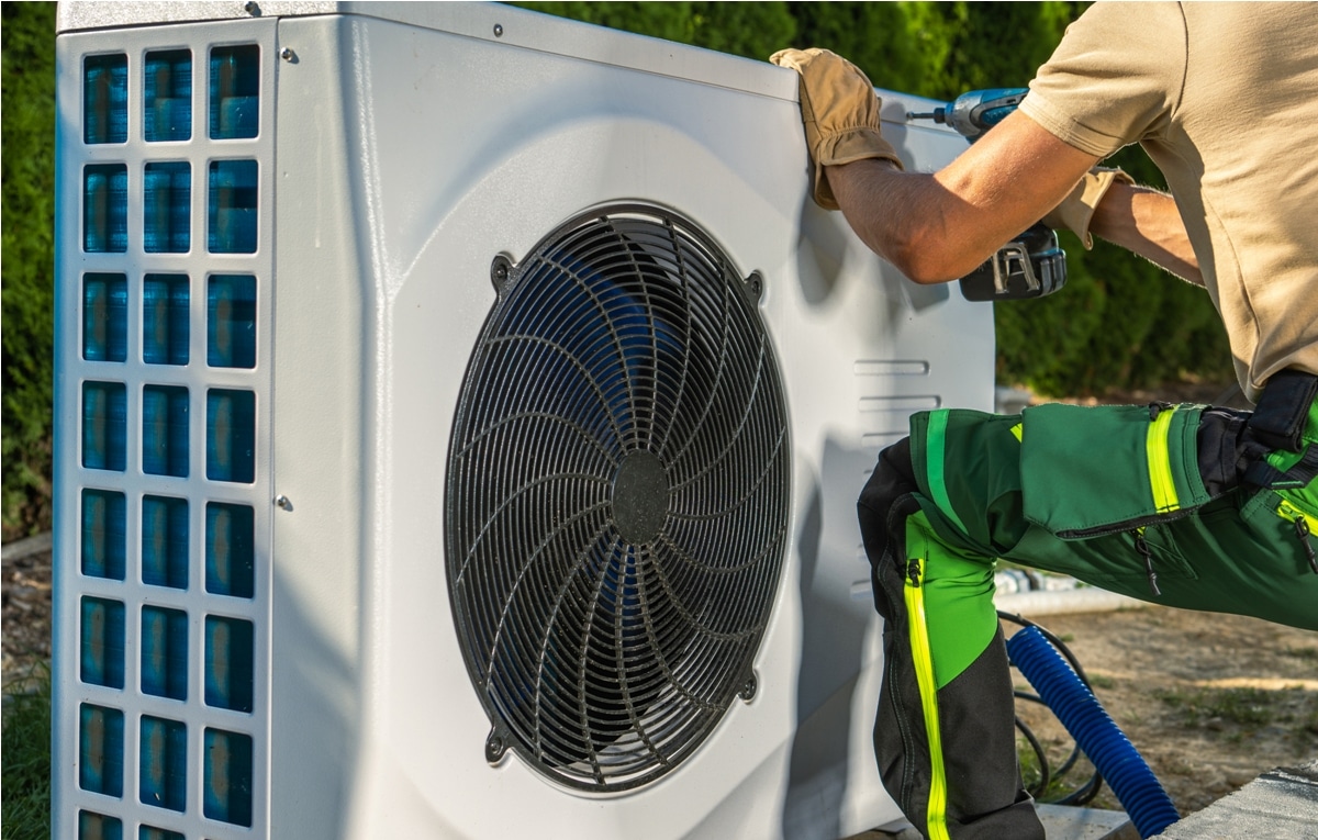 hvac worker installing electric heat pump