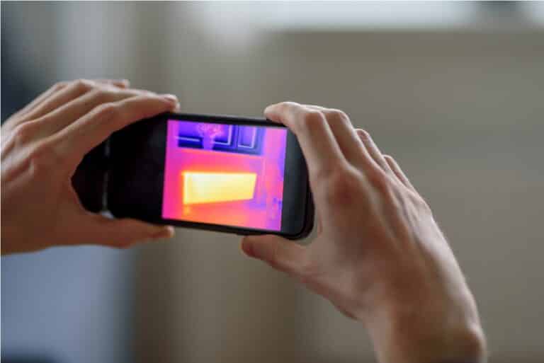 person doing thermal scanning of apartment