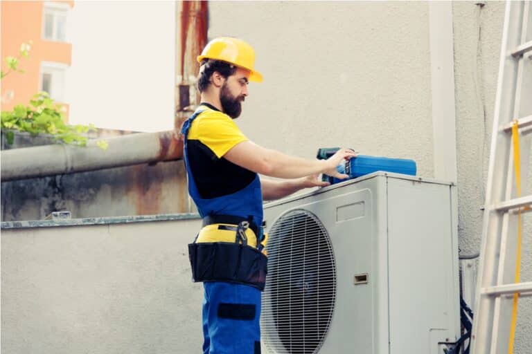trained engineer mending air conditioner