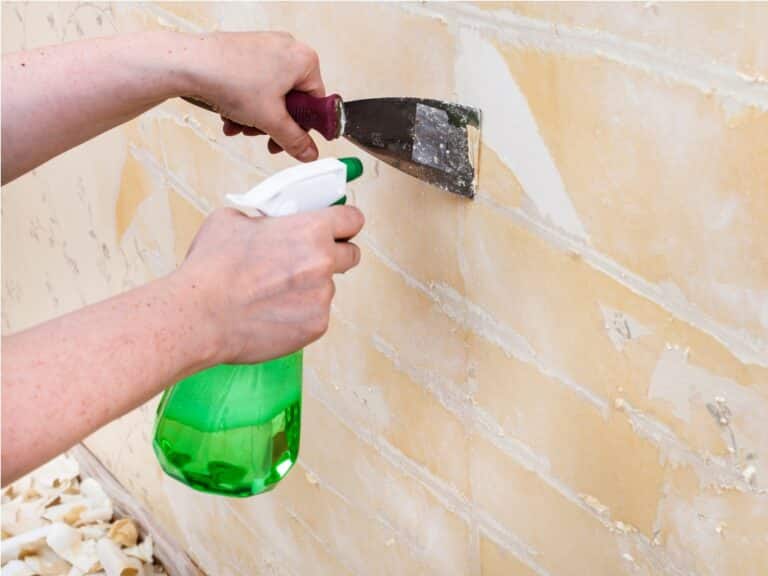 cleaning wall from wet old wallpaper with spatula